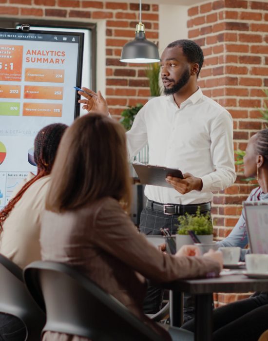 Company employee presenting business strategy with charts Company employee presenting business strategy with charts on monitor, planning project. Workmates analyzing financial statistics on display, working together on company development.